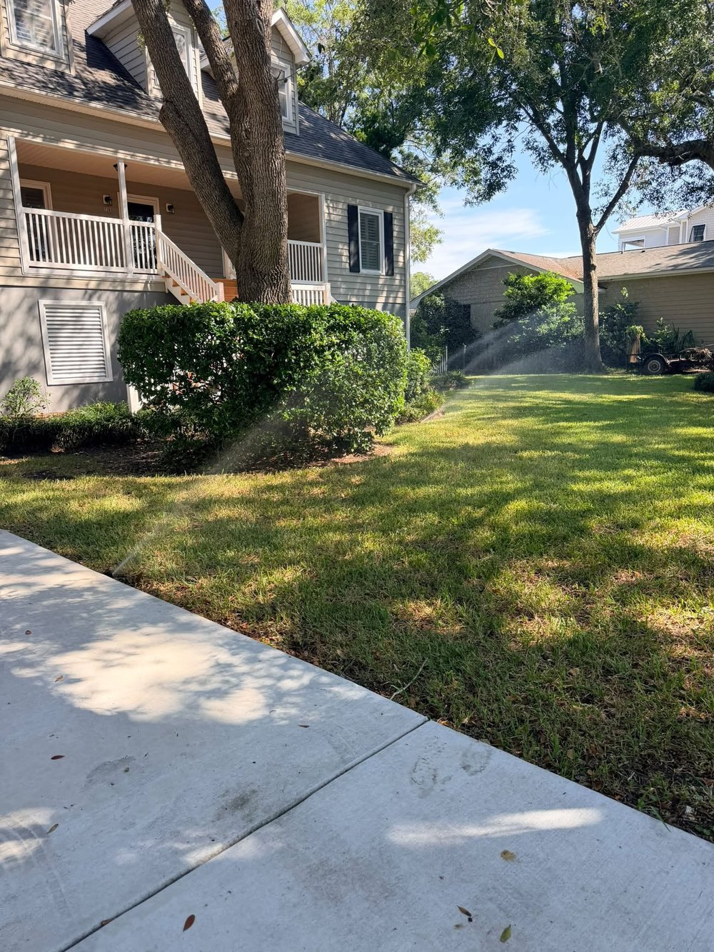 A Bess Irrigation sprinkler zone actively watering a shaded front lawn